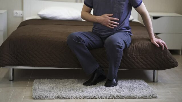Stomach ache, man with abdominal pain suffering at home, health problems concept