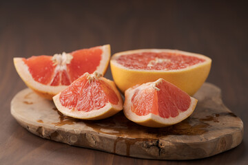 Naklejka na ściany i meble Sliced grapefruit on wood board closeup