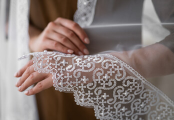 wedding veil close-up of embroidered pattern on hand.