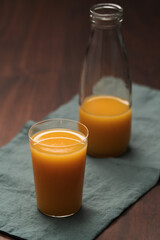 Fresh organic orange juice in tumbler glass on wood table