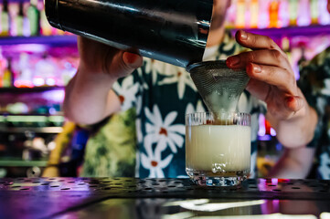 man hand bartender making white cocktail in glass on the bar counter