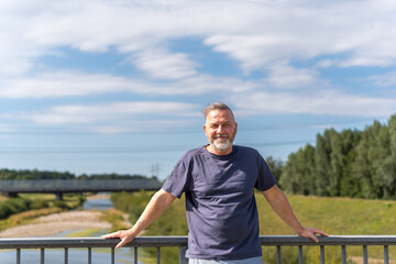Smiling middle aged man on a bridge