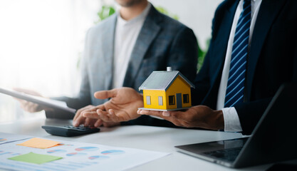 Buying a home or insurance deal, an insurance agent pointing a pen to those interested in renting a house, a contract, signing an Home buying agreement