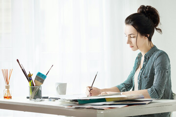 Artist`s model. girl painter working in the office. the girl draws on canvas. artist`s workplace