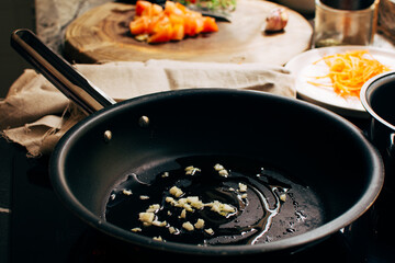 Frying garlic in frying pan, cooking at home