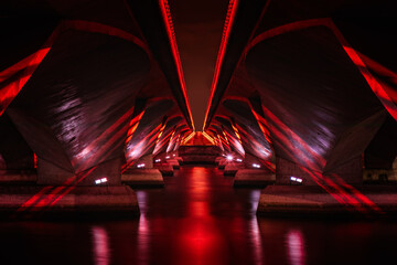 Red lights under a modern concrete bridge