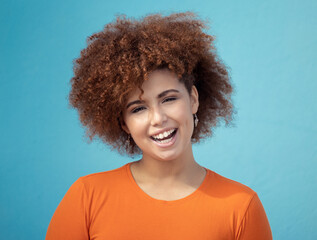Black woman, portrait smile and afro for profile, vision hair style against blue studio background. Happy African American female smiling with teeth in joyful happiness or positive attitude on mockup