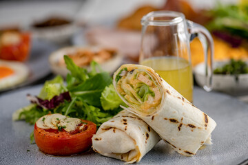 Mix dish Vegetarian breakfast salad with eggs Benedict, egg burrito, juice, toasted muffins, ham, poached eggs, and delicious buttery hollandaise sauce with fresh salad.