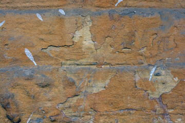 The old shabby walls of the old house, hewn with peeling paint, large and small cracks in the gray concrete wall.