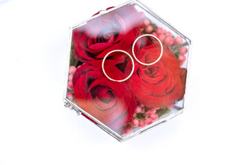 wedding ceremony rings in a box with roses on a white background