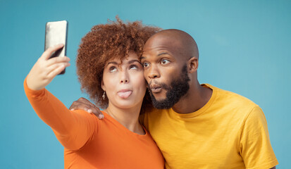Couple, hug and funny faces selfie on blue background, isolated mockup or wall mock up for social media. Comic, goofy and silly black man and woman on photography tech for interracial profile picture - obrazy, fototapety, plakaty