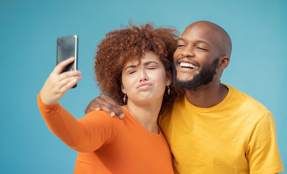 Couple, bonding or funny faces selfie on blue background, isolated mockup or wall mock up on social media. Comic, goofy or silly man and woman on photography technology in interracial profile picture