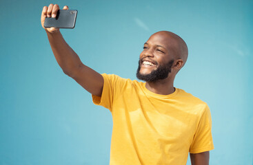 Black man, happy or selfie on blue background, isolated mock up or wall mockup for social media app or vlogging. Smile, blogger or influencer on tech photography for live streaming or profile picture