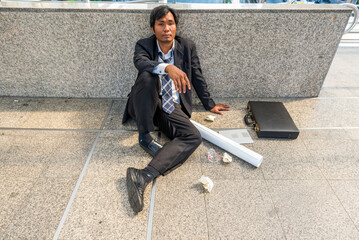 business man in suit frustrated he sad for lost work job sit on street upset fail unhappy after...