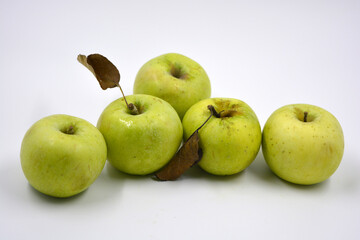 Beautiful and juicy, ripe fruits, fruits of the tree. Green apples with dry leaves, Simirenko varieties are located on a white background.