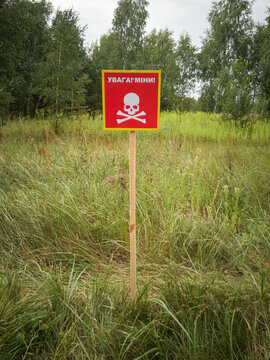 Ukrainian mine danger sign in the forest. Translation: "attention - mine's"