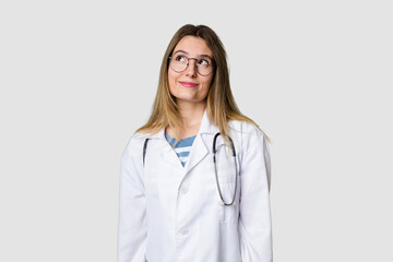 Compassionate female physician with a stethoscope around her neck, ready to diagnose and care for her patients in her signature white coat dreaming of achieving goals and purposes