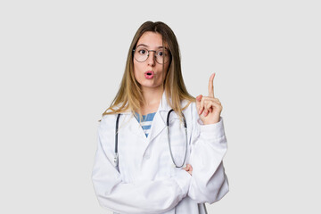 Compassionate female physician with a stethoscope around her neck, ready to diagnose and care for her patients in her signature white coat having some great idea, concept of creativity.