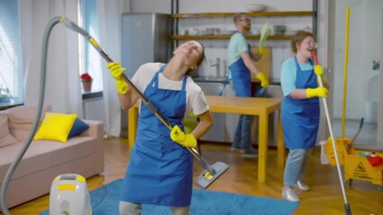 Funny workers of cleaning service cleaning up and dancing. Realtime