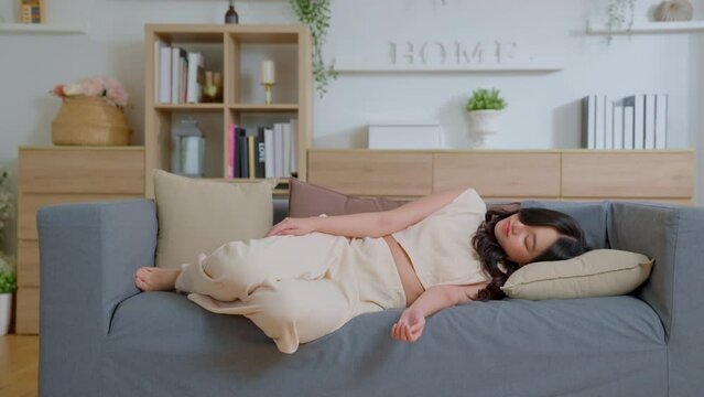 Young asian woman exhausted or bored young sleepy falls down on sofa. Apathetic tired lazy female sleeping on couch at new home Alone. Moving into a new home. Fatigue or depression concept.