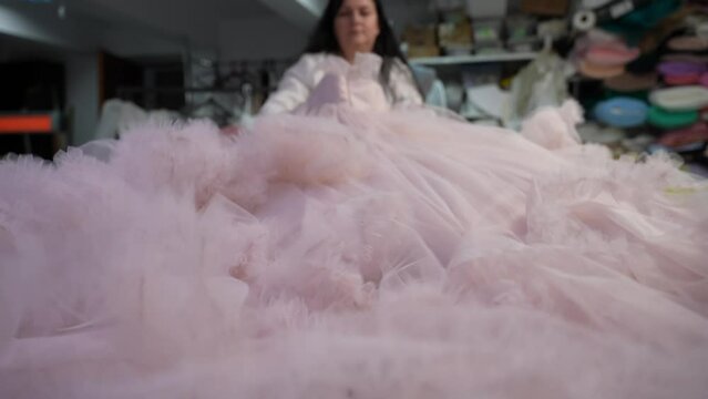 A woman sews a tulle dress