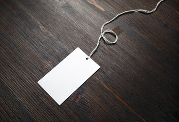 Blank white paper tag on wooden background. Copy space for text.