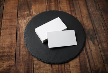 Photo of blank business cards and round slate plate. Mock-up for branding identity.