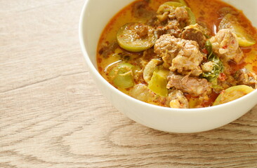 spicy boiled beef meat with eggplant in coconut milk green curry soup on bowl 