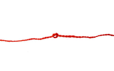 Red thread isolate on white background. Selective focus. Old.