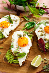 Egg and avocado toast, sandwiches with eggs and fresh greens. Healthy diet food. Top view