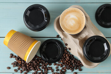 Paper cups with cappuccino and coffee beans on a blue table. coffee to go