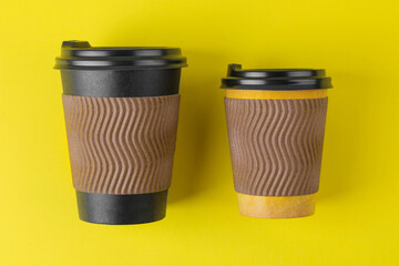 Paper cups for hot drinks of different sizes on a yellow background. coffee to go