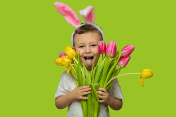 Happy Easter. A child in a rabbit costume holds a bouquet of yellow and pink tulips. A charming...