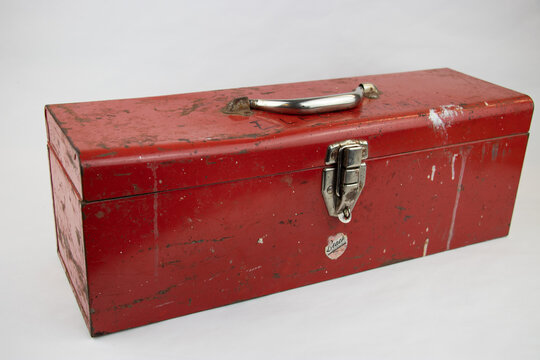 Old red retro handyman toolbox on white background