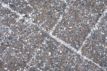 Salt grains on paving slabs closeup. Salted sidewalk, slipping prevention. Treatment road and...