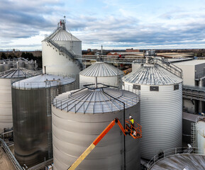 An engineer working at height on a cherry picker or aerial work platform © teamjackson