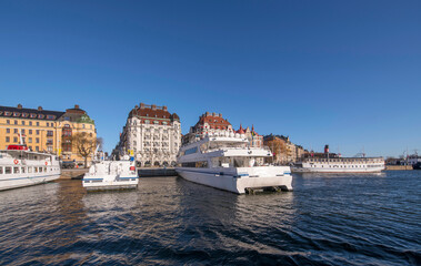Fototapeta na wymiar Panorama, pier at the jetty Strandvägen with commuter boats, waterfront hotels, offices and apartment buildings a sunny winter day in Stockholm