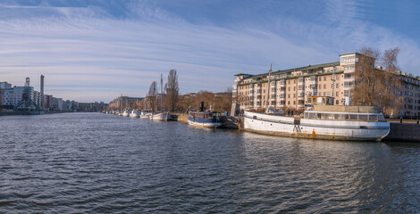 Panorama, Old fishing boats at a pier in the district Hammarbyhamnen a sunny winter day in Stockholm