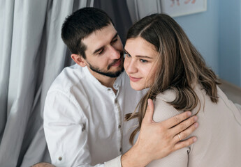 Loving everything about her. Beautiful young couple bonding and smiling while sitting in the bedroom