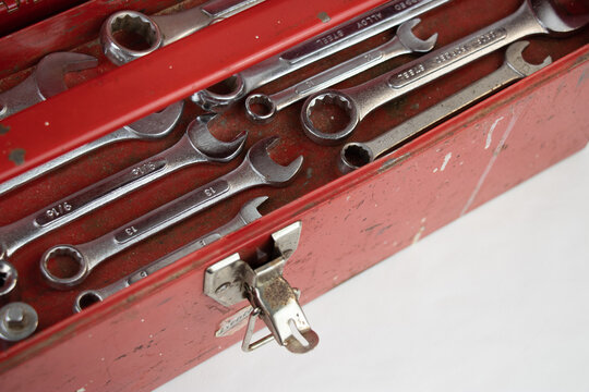 Old red retro handyman toolbox on white background