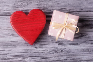 Fototapeta premium Red valentines heart and gift box on wooden background. Valentine’s day gift concept