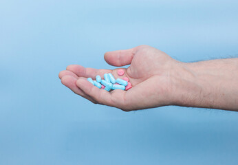 An elderly man has pills in his hands for health. The concept of treatment with pills prescribed by...