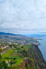 Fototapeta na wymiar A picturesque view from a height of the green coast of madeira Island.