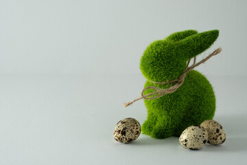 Easter green bunny rabbit figure and quail eggs on light background. Space for you text