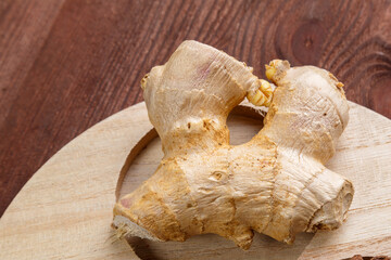 Ginger fragrant spicy spice on a handmade wooden stand.