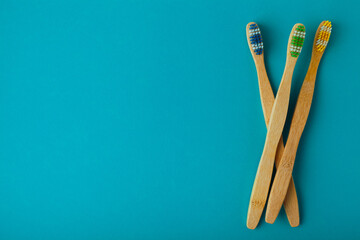 multiple bamboo toothbrush pile on blue background