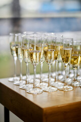 close up arranged glass on the table in abstract field in celebration time for any luxury background. many glasses of champagne, close-up, bokeh
