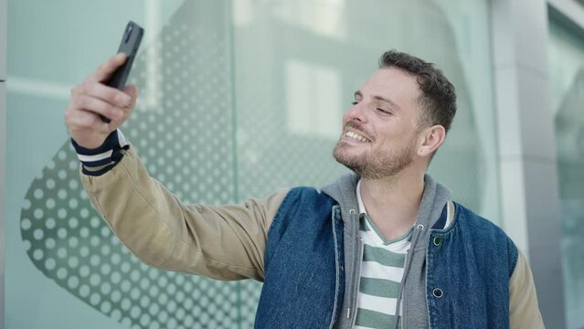 Young caucasian man smiling confident taking selfie picture at street