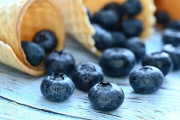 blueberries scattered from a waffle cone on the table. dessert. healthy diet