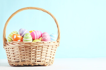 Colorful easter eggs in basket on blue background - 570689780